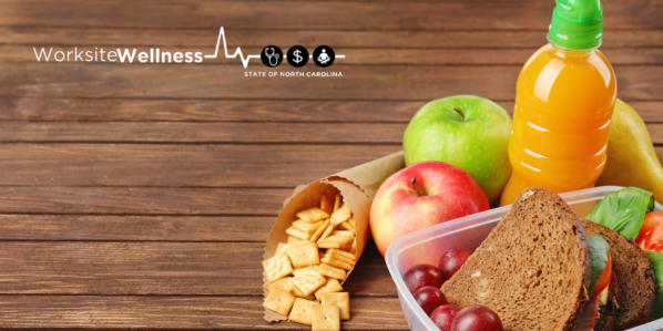 Grapes and Sandwhich in a plastic container with an orange drink and apples